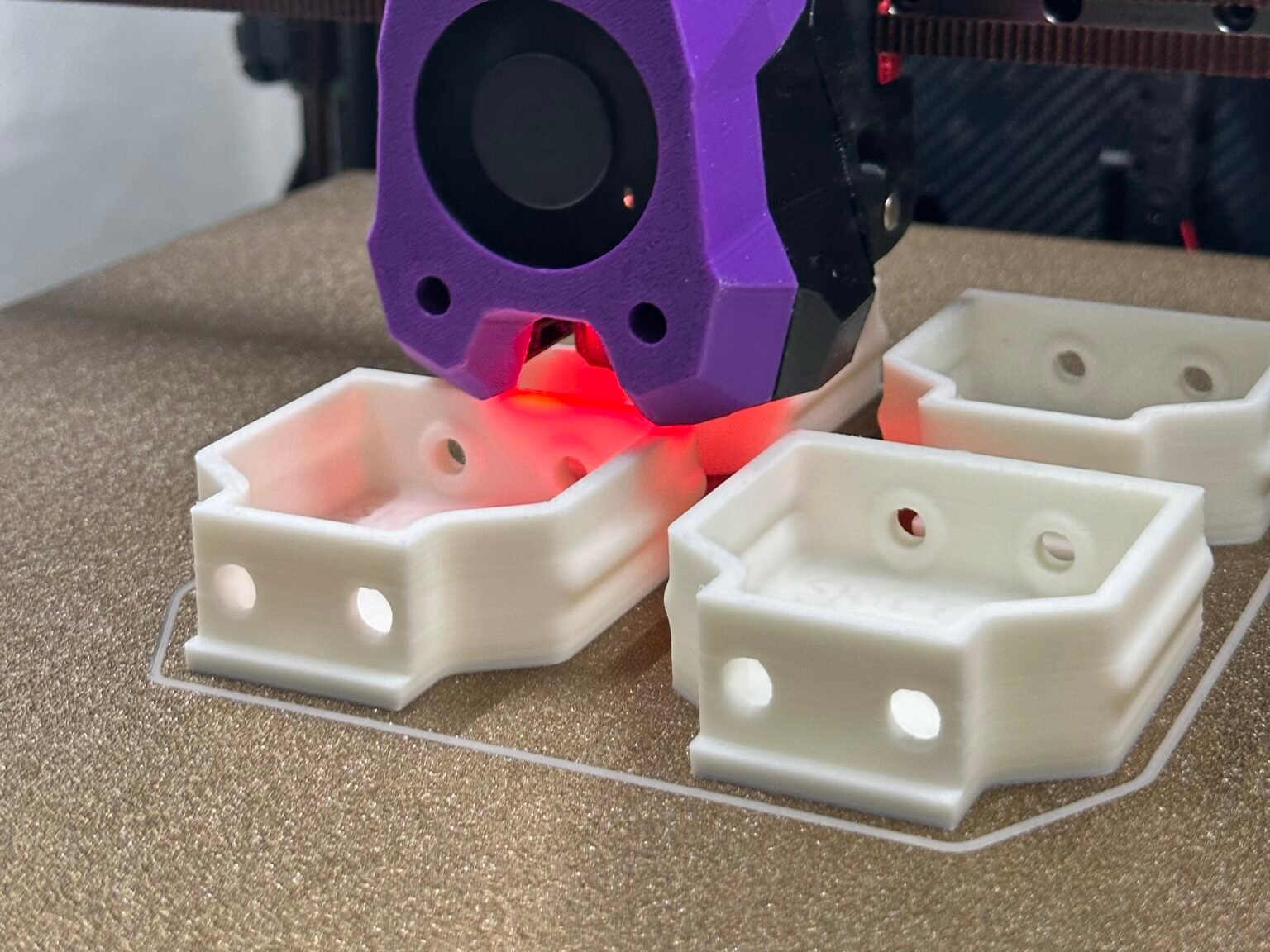 Voron 3D printer extruder printing plastic parts on the build plate